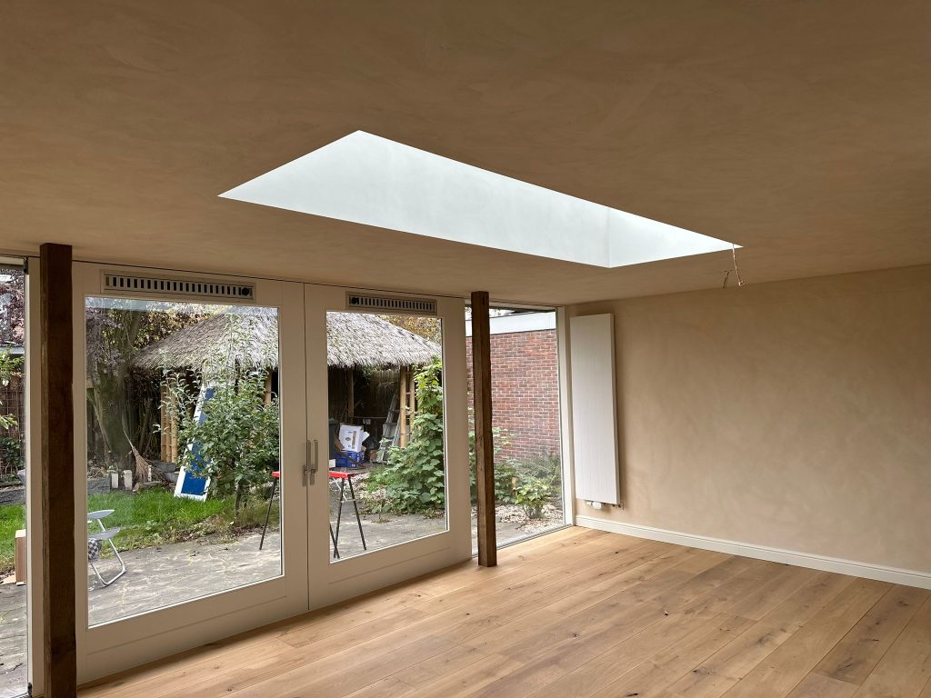Modern living room with skylight and French doors to garden.