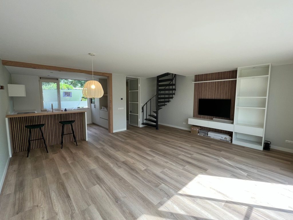 Moderne woonkamer met keuken en trap.