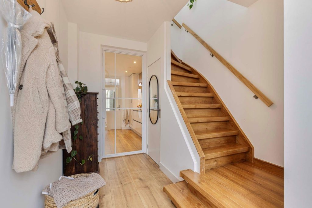 Modern wooden staircase in bright hallway.
