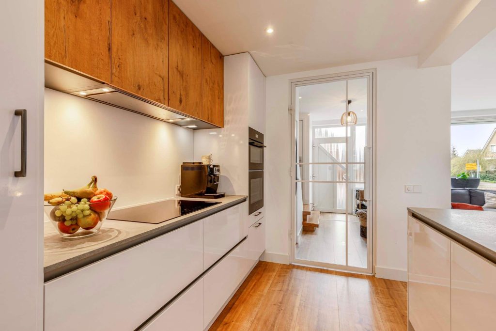 Modern kitchen with wooden cabinets and glass door
