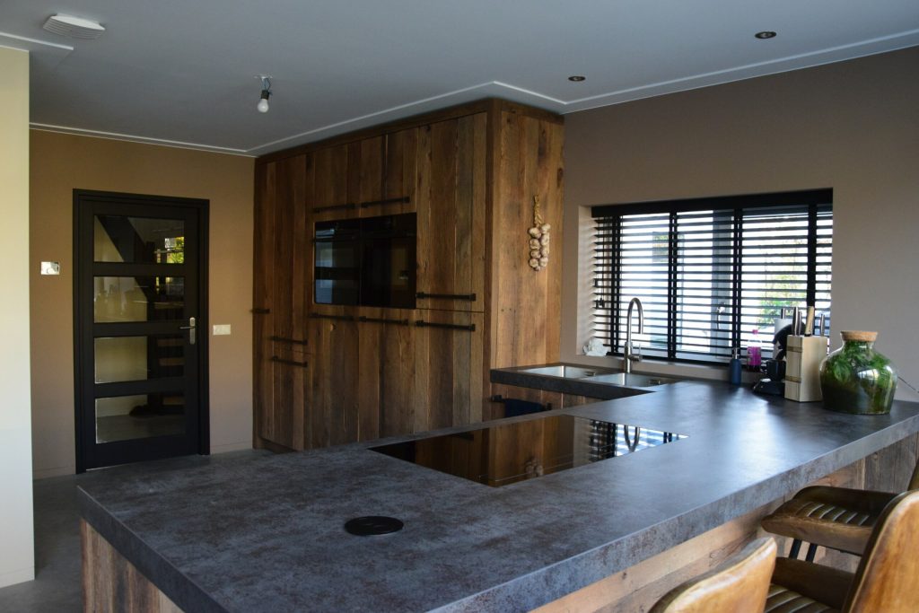 Moderne keuken met houten elementen en werkblad.