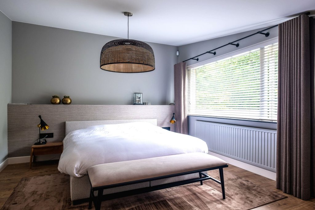 Moderne slaapkamer met bed en grote lampenkap.