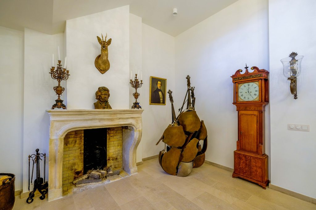 Klassieke kamer met haard, standbeeld en houten klok.