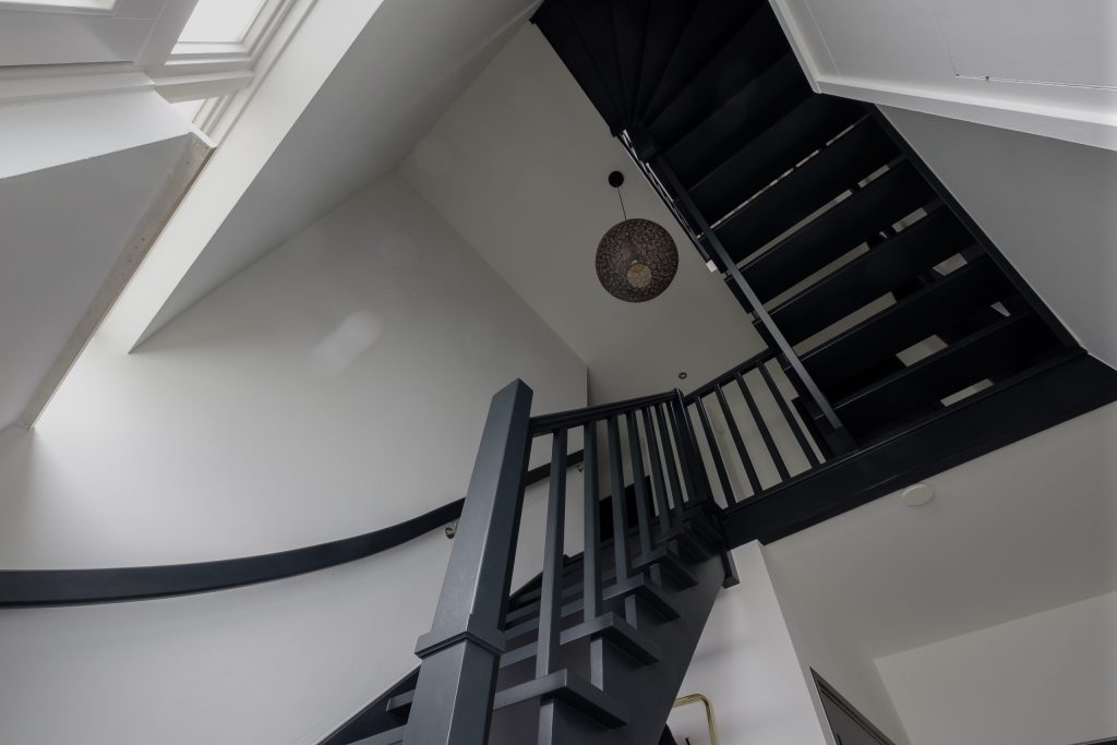 Zwarte trap naar boven met hanglamp