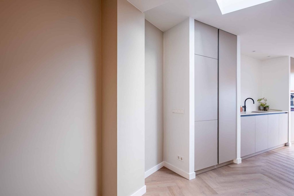 Moderne keuken met wit interieur en houten vloer.