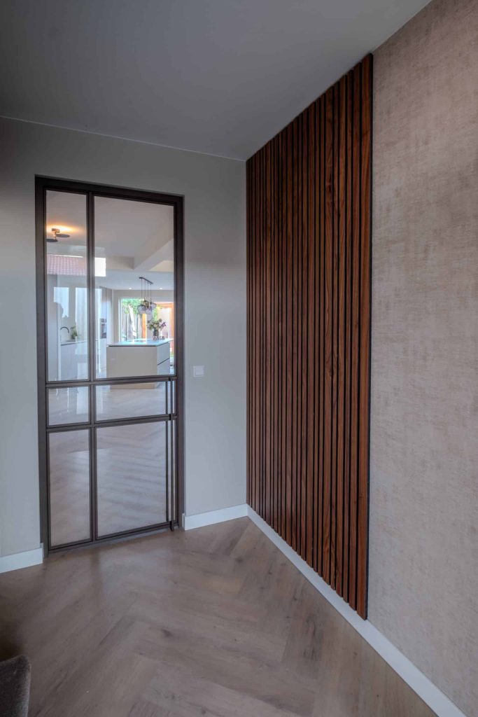 Moderne gang met glazen deur en houten wand.