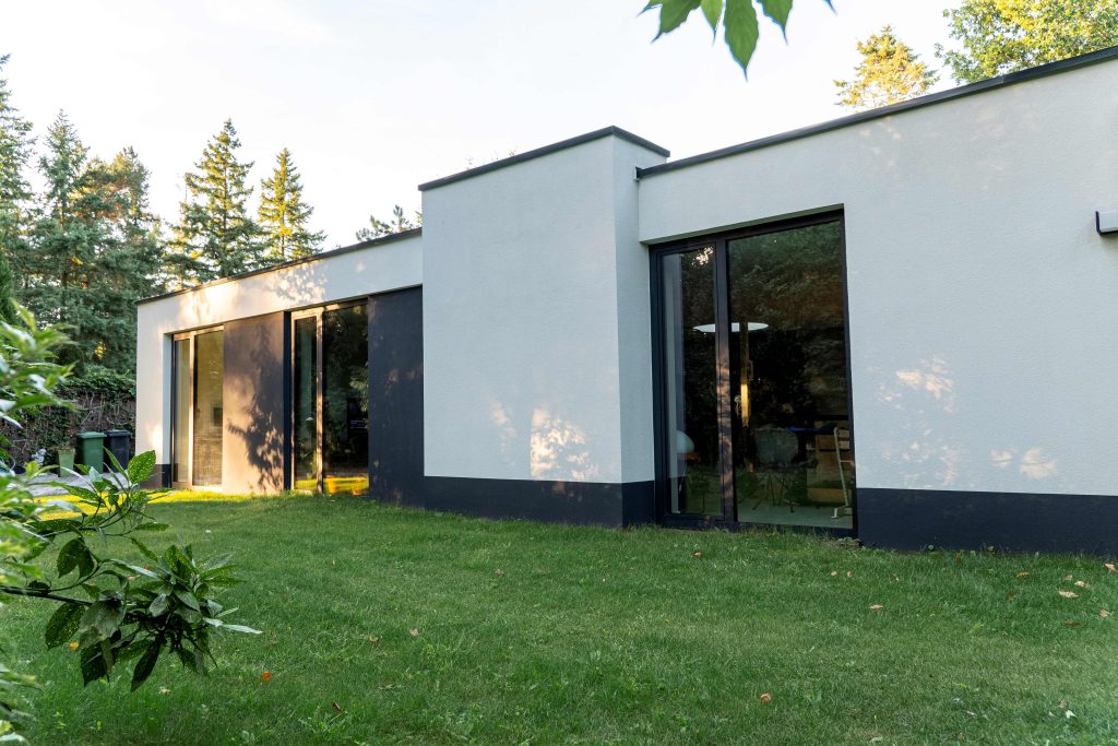Moderne bungalow met grote ramen en tuin