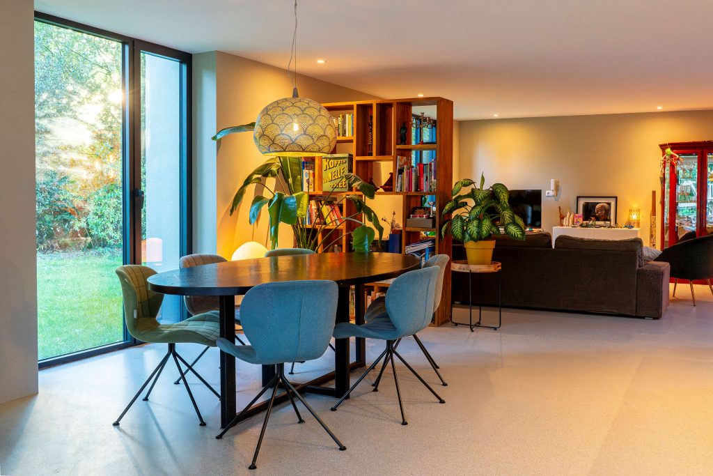 Modern living room with dining area and lots of plants.