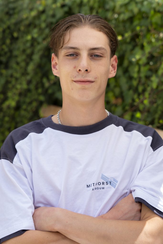 Jonge man met kort haar buiten in witte t-shirt