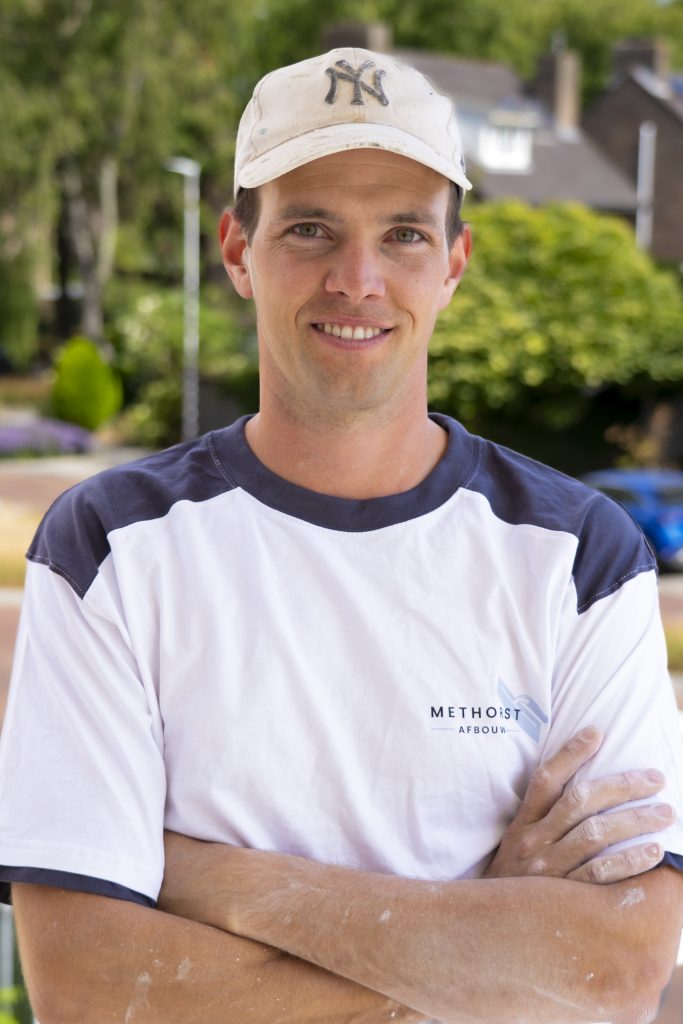 Lachende man met pet en wit T-shirt